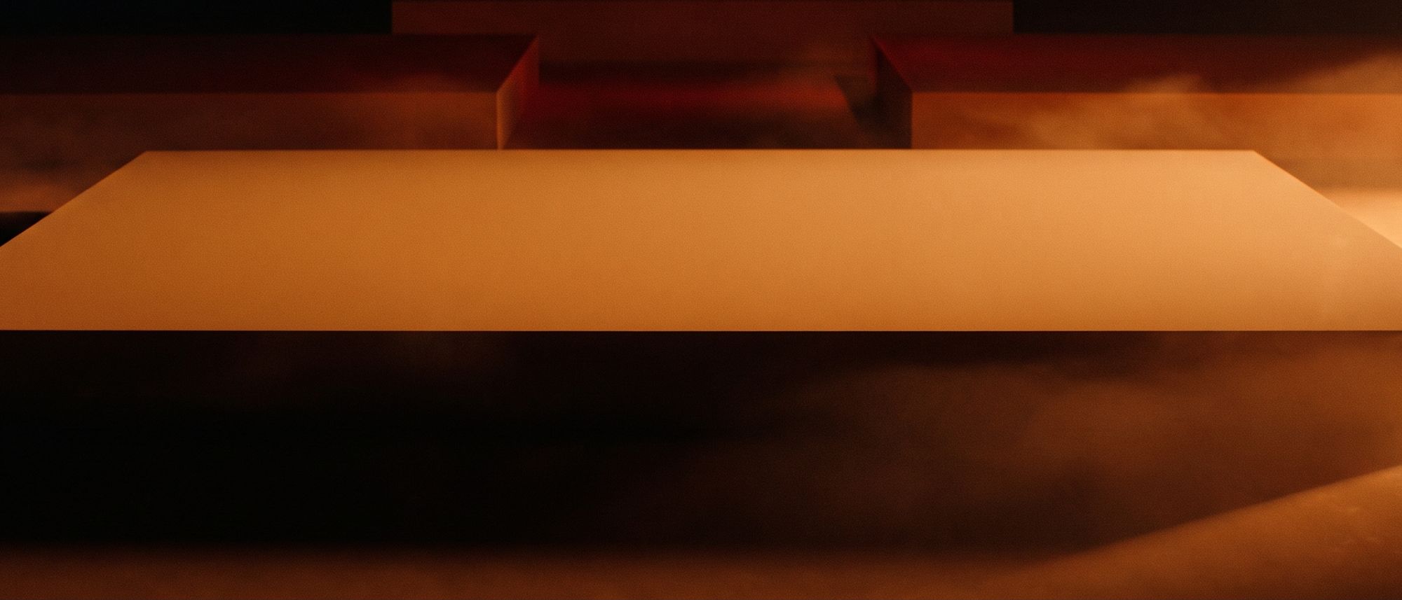Abstract orange and black composition of a smooth featureless plane lit from a low angle, with depth behind it